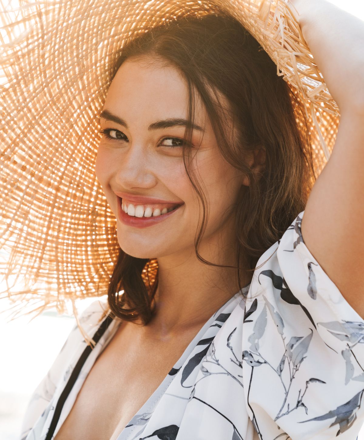Smiling Sarasota Thermage model wearing a large straw hat.